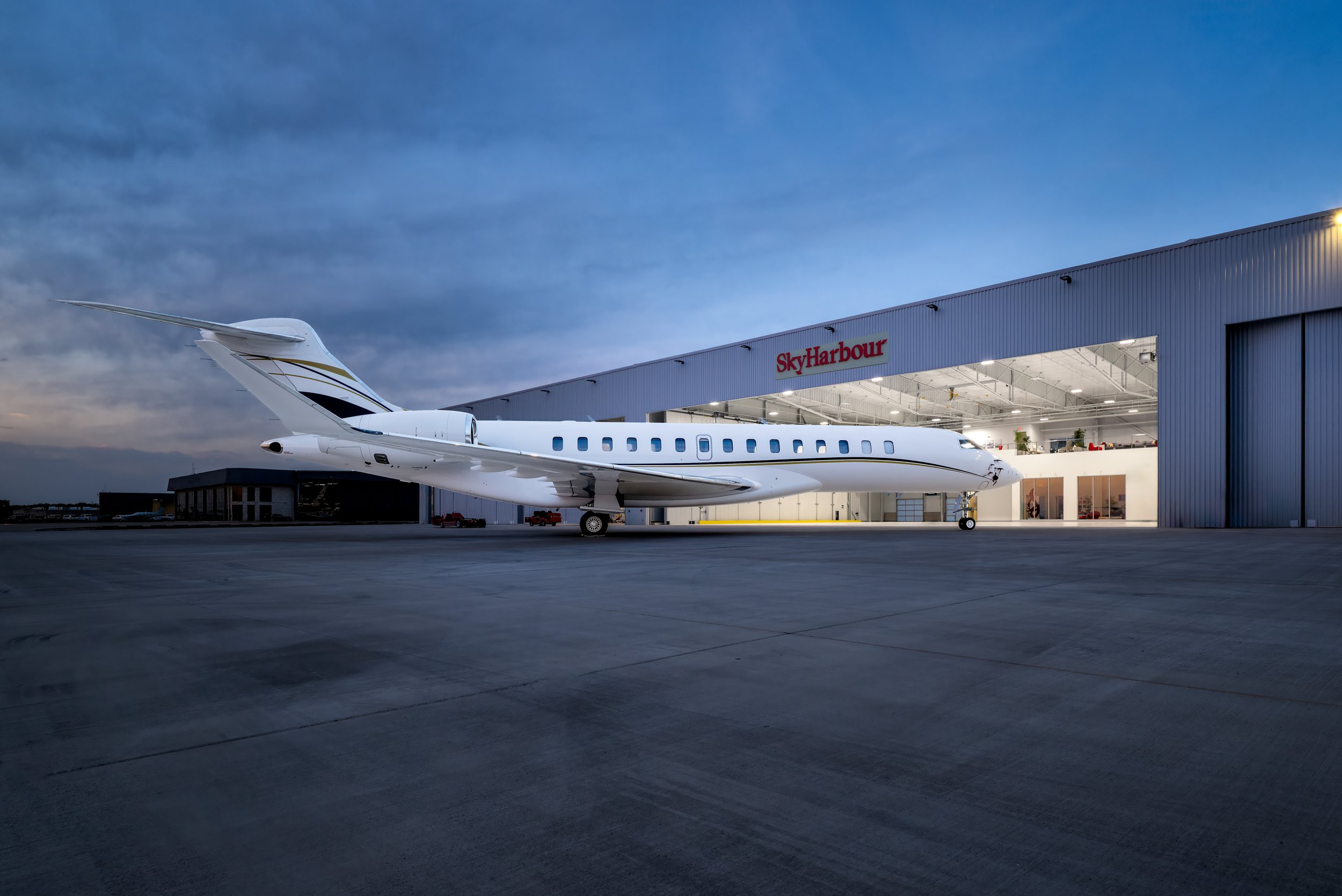 Private jet parked in front of a Sky Harbour hangar at dusk